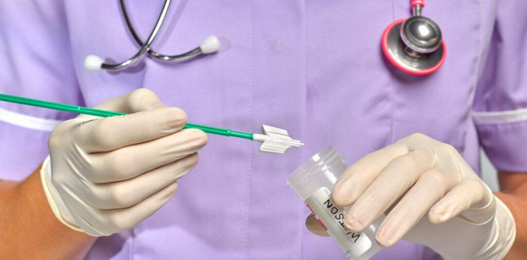 врач проводит мазок на ИППП