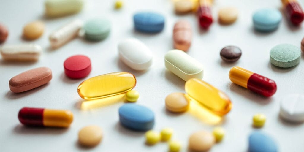 капсулы с витаминами в баночках на фоне предупреждения