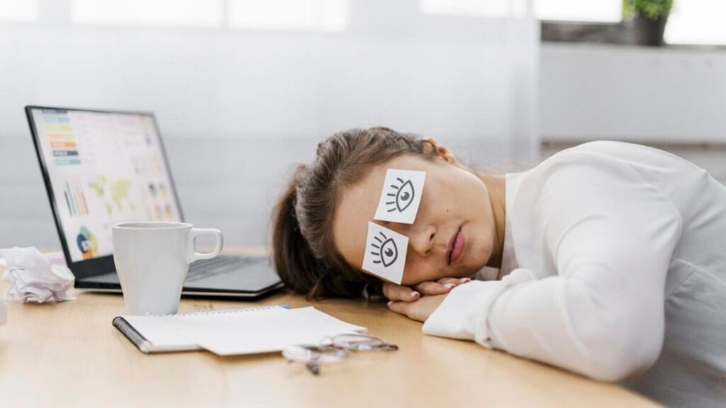 A person with symptoms of chronic fatigue sits in bed.
