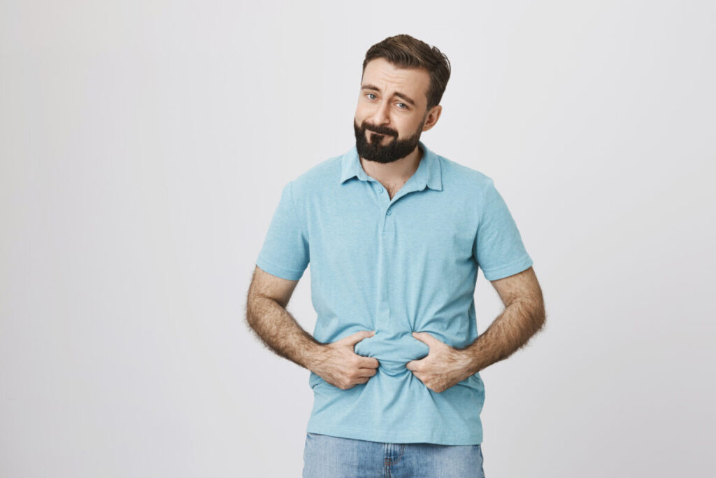 Food intolerance – a person holds their stomach after eating